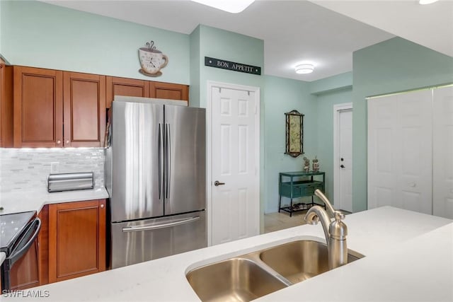 kitchen with decorative backsplash, sink, stainless steel refrigerator, and black electric range