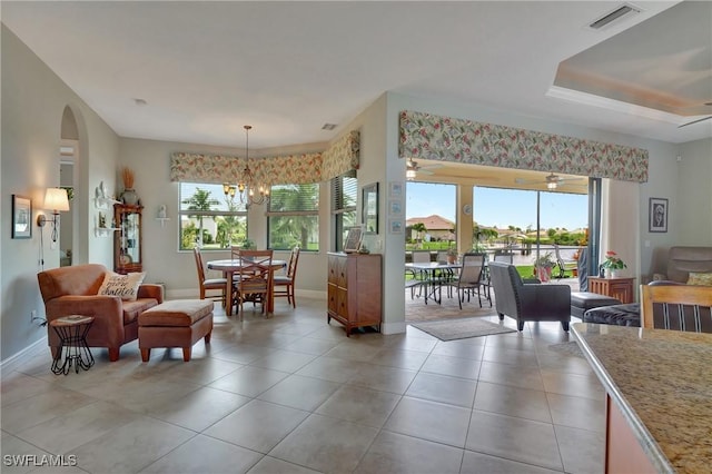 tiled dining space featuring an inviting chandelier and plenty of natural light