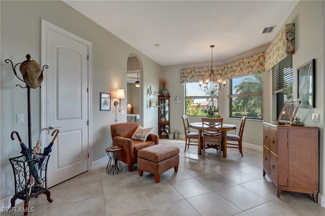 dining room with light tile patterned floors and ceiling fan with notable chandelier