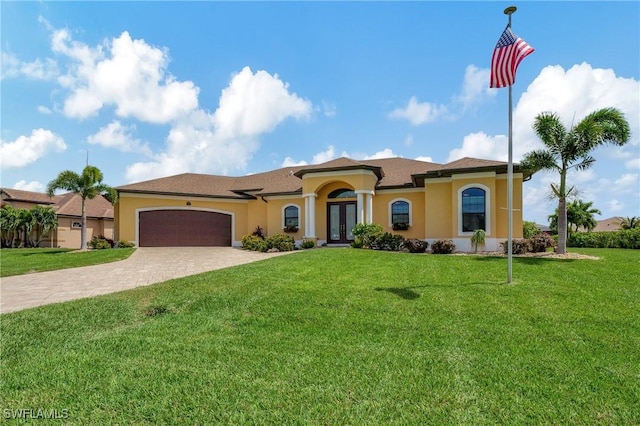 mediterranean / spanish-style house featuring french doors, a front yard, and a garage