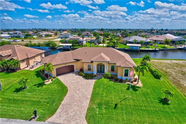 view of front of home featuring a garage, a water view, and a front yard