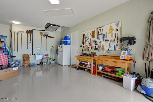 garage featuring a workshop area and white refrigerator