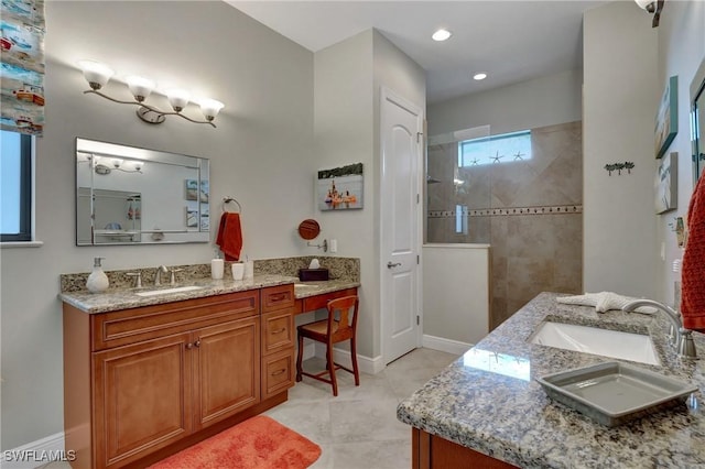 bathroom featuring tile patterned flooring, vanity, and a tile shower