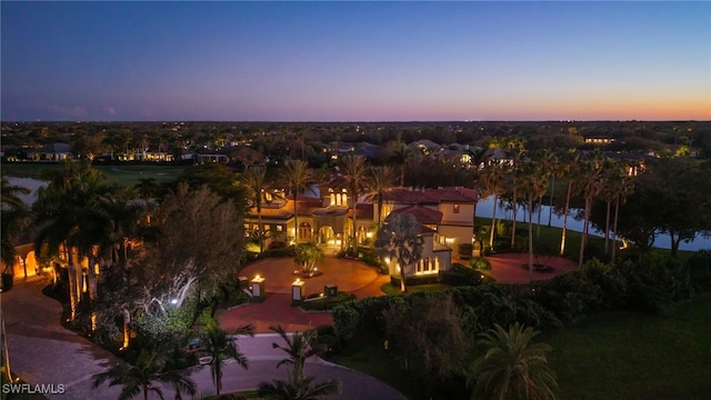 aerial view at dusk featuring a water view