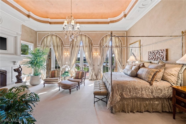 carpeted bedroom with an inviting chandelier, a tray ceiling, ornamental molding, and a towering ceiling