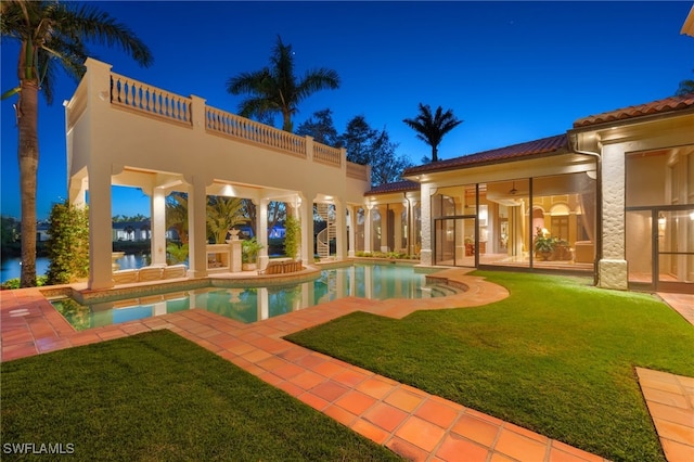 view of swimming pool featuring a patio, a yard, and ceiling fan