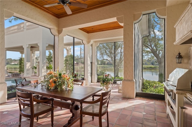 sunroom featuring wooden ceiling, ceiling fan, and a water view