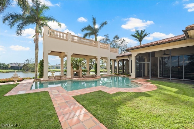 view of swimming pool featuring a water view, ceiling fan, and a yard