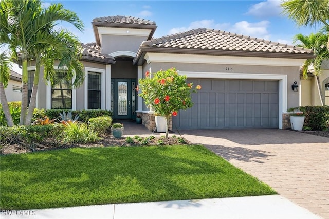 mediterranean / spanish home featuring a garage and a front lawn