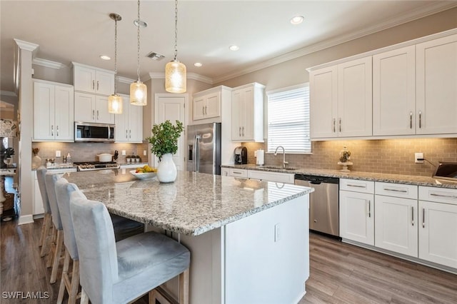 kitchen with stainless steel appliances, a center island, and white cabinets