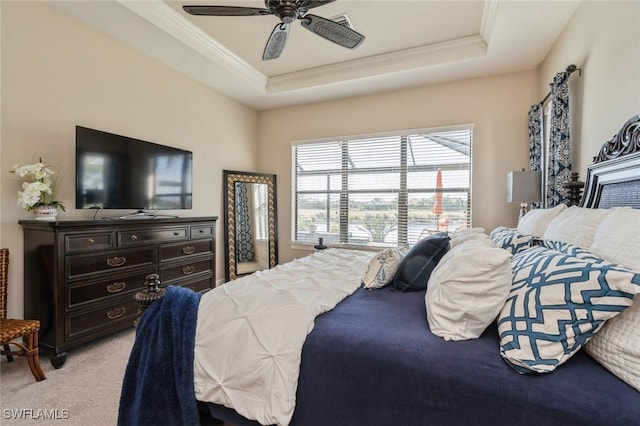 bedroom with ceiling fan, a raised ceiling, and light carpet