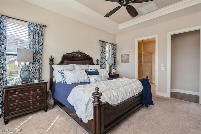 bedroom featuring multiple windows, light colored carpet, ceiling fan, and ensuite bathroom