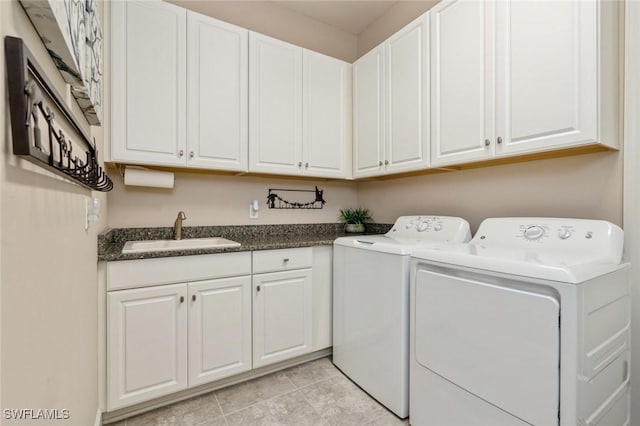 washroom featuring sink, light tile patterned floors, cabinets, and washer and dryer