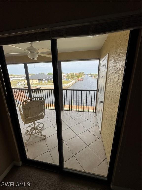 doorway with a water view and ceiling fan