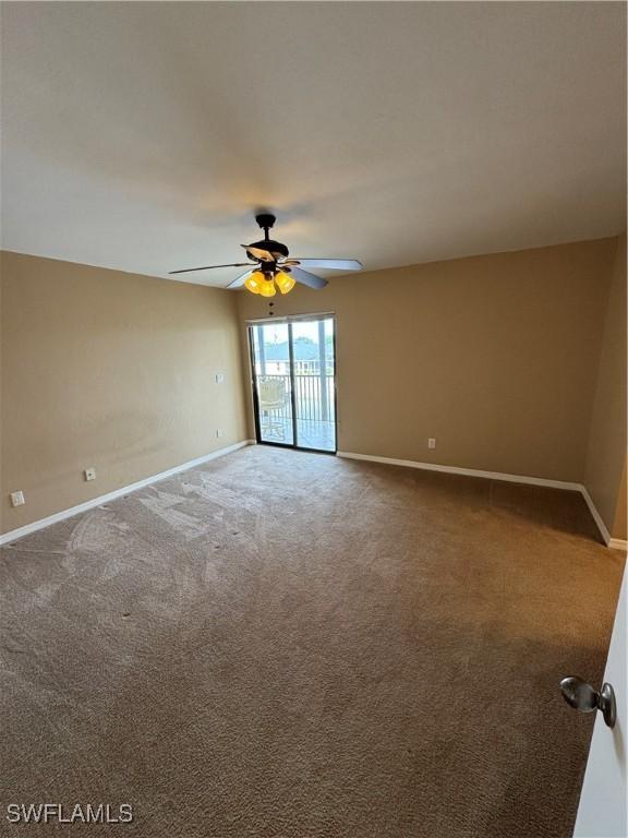 carpeted spare room featuring ceiling fan