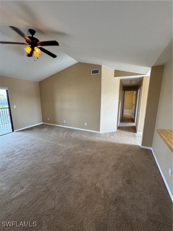 carpeted spare room with ceiling fan and vaulted ceiling