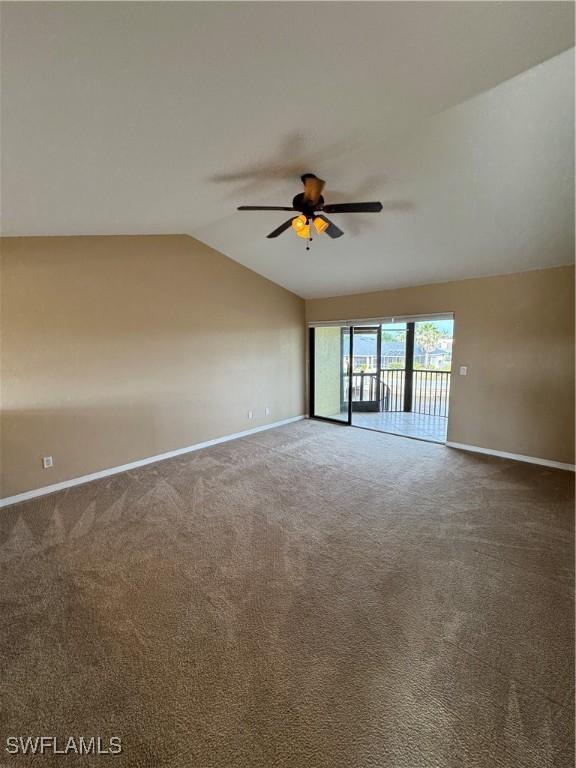 carpeted empty room featuring ceiling fan and vaulted ceiling