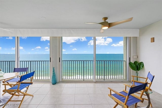 sunroom featuring a water view and ceiling fan