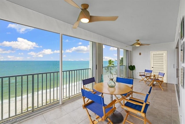 sunroom featuring a water view, a beach view, and ceiling fan