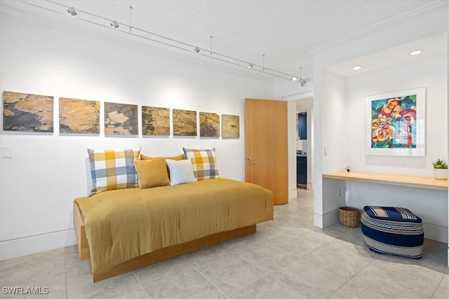 bedroom with crown molding, track lighting, and a textured ceiling