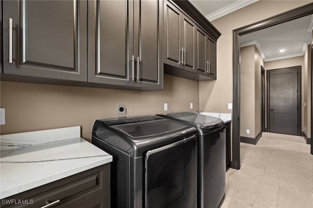 clothes washing area featuring ornamental molding, cabinets, and independent washer and dryer