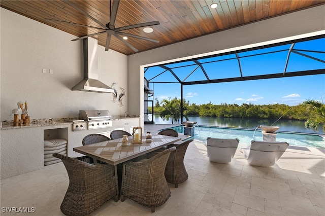 view of patio / terrace with exterior kitchen, grilling area, ceiling fan, and a water view