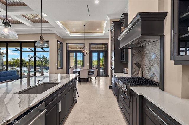 kitchen with pendant lighting, stainless steel appliances, french doors, ornamental molding, and sink