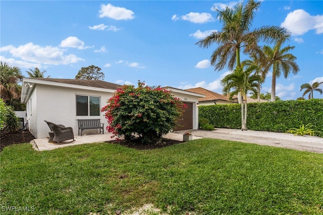 view of front of home with a garage and a front lawn