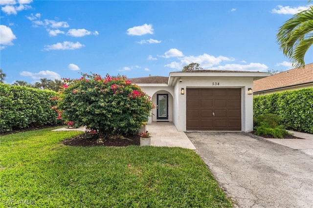 ranch-style home with stucco siding, asphalt driveway, an attached garage, and a front yard