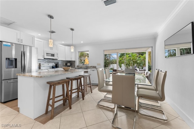 dining room featuring light tile patterned flooring and crown molding