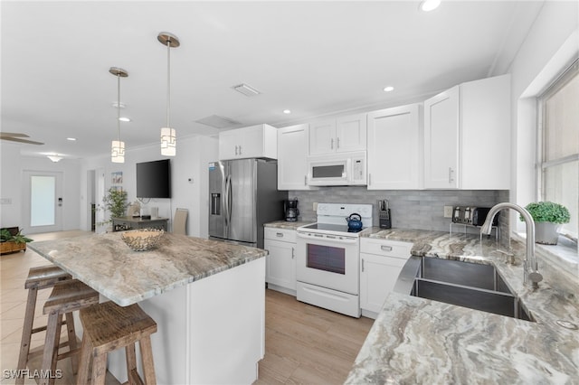 kitchen featuring white cabinets, white appliances, tasteful backsplash, and sink