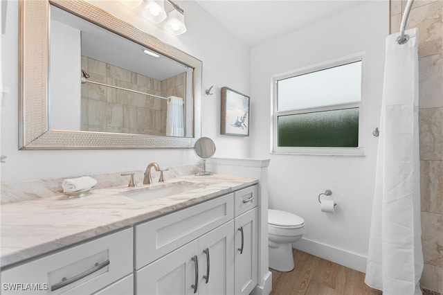 bathroom with a shower with curtain, toilet, vanity, and hardwood / wood-style flooring