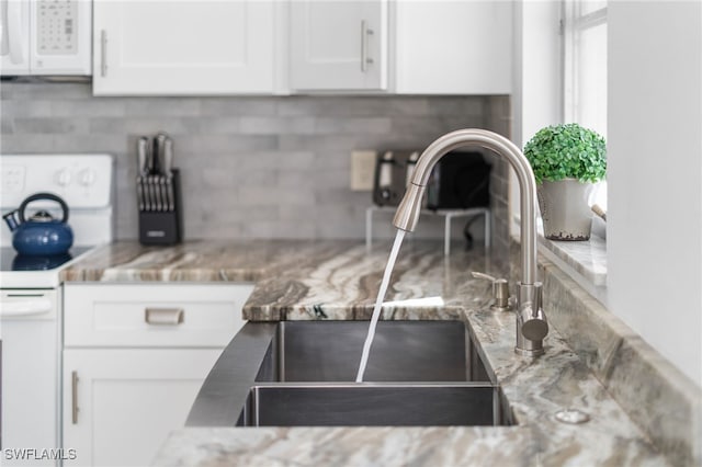 kitchen with light stone countertops, sink, white appliances, decorative backsplash, and white cabinets