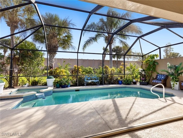 view of swimming pool featuring a patio, glass enclosure, and an in ground hot tub