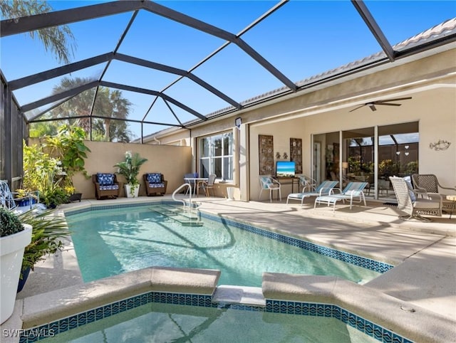 view of swimming pool with ceiling fan, a patio, and glass enclosure