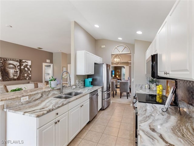 kitchen with light stone countertops, white cabinets, appliances with stainless steel finishes, sink, and light tile patterned flooring