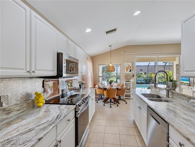 kitchen with backsplash, vaulted ceiling, sink, white cabinetry, and appliances with stainless steel finishes