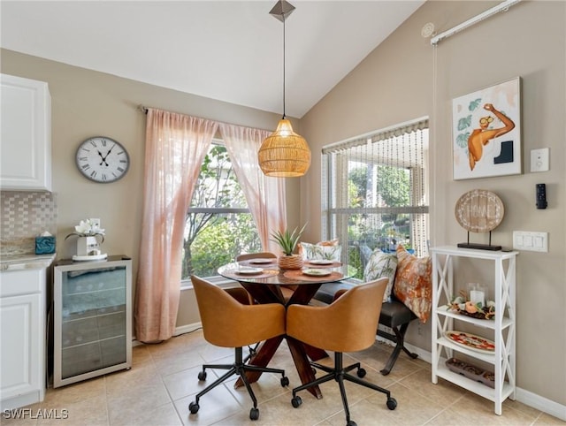 tiled dining area with vaulted ceiling and beverage cooler