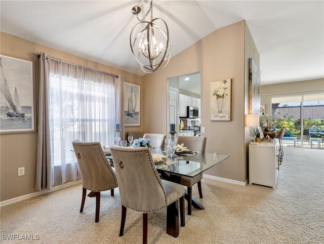 carpeted dining room featuring a chandelier and lofted ceiling