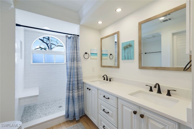 bathroom featuring vanity, curtained shower, wood-type flooring, and ornamental molding