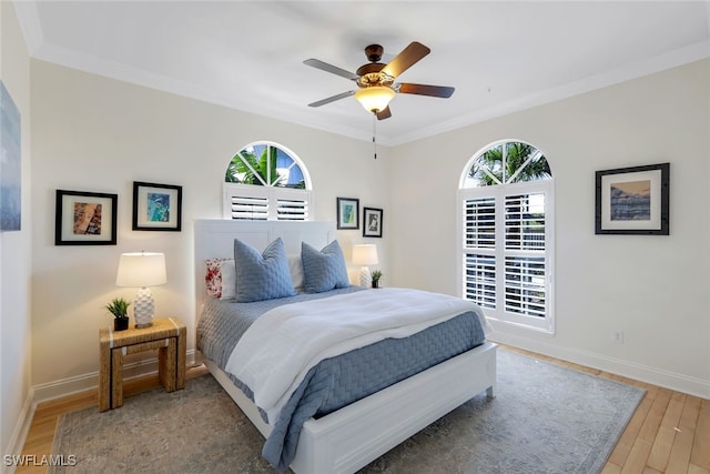 bedroom with hardwood / wood-style floors, ceiling fan, and ornamental molding