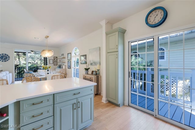 kitchen with gray cabinets, hanging light fixtures, and light wood-type flooring