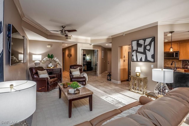 living room with ceiling fan and ornamental molding