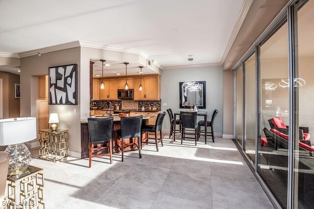 kitchen with decorative light fixtures, tasteful backsplash, and ornamental molding