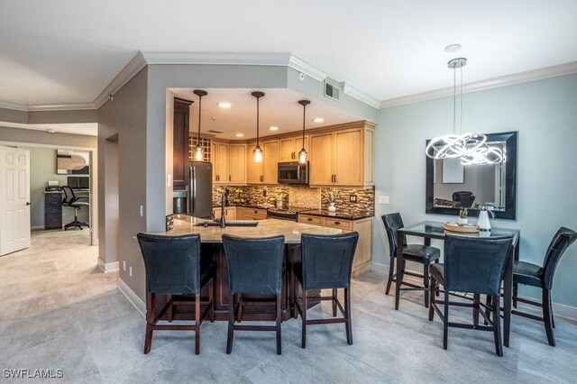 kitchen with stainless steel appliances, sink, light brown cabinets, decorative light fixtures, and a notable chandelier