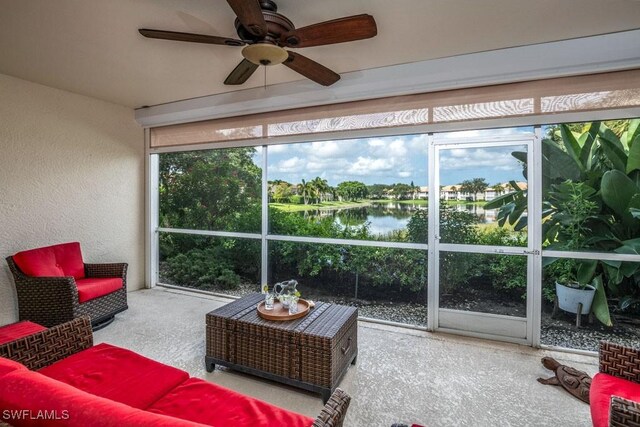 sunroom / solarium with a water view and ceiling fan