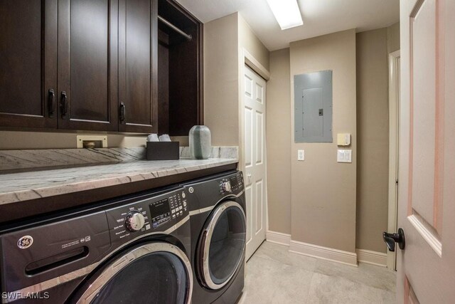 laundry room featuring cabinets, washing machine and dryer, and electric panel