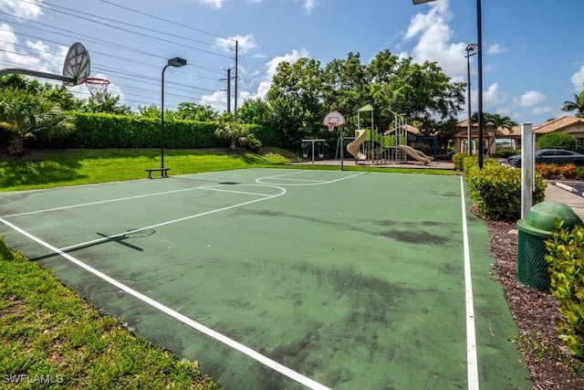 view of basketball court with a playground and a lawn