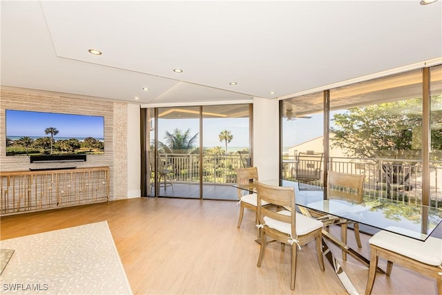 dining space with light hardwood / wood-style flooring, floor to ceiling windows, and plenty of natural light