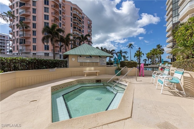 view of swimming pool featuring a patio area and a hot tub